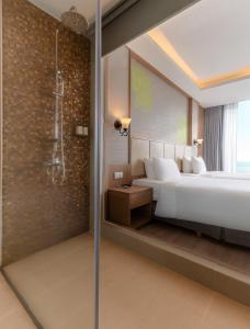 a bedroom with a large bed and a shower at Navada Beach Hotel in Nha Trang