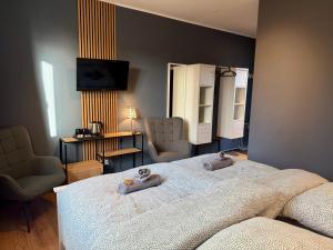 a bedroom with a bed with two stuffed animals on it at Die Schlafstube - Boutiquehotel in Neuharlingersiel