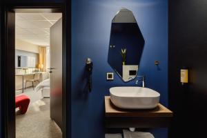 a bathroom with a sink and a blue wall at Yuko Residence in Jasło