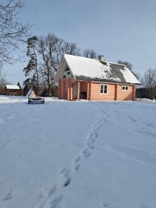 a footprints in the snow in front of a house at Vahtramäe saun in Siniküla