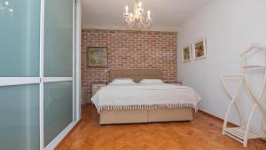 a bedroom with a bed and a brick wall at Villa Alenor – Sea View & Beach Access in Nesebar