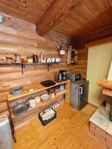 a kitchen with wooden walls and wooden flooring in a cabin at Vahtramäe saun in Siniküla +6 photos