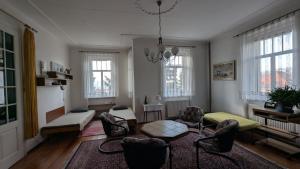 a living room with a couch and chairs and windows at Pension Central in Ústí nad Labem