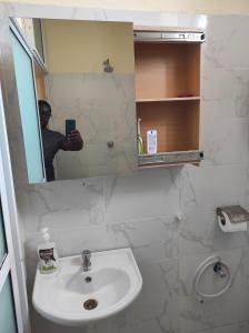 a man taking a picture of a bathroom mirror at GCG STAYS ltd in Mtwapa +12 photos