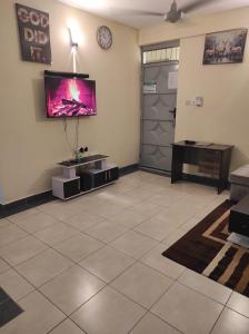 a living room with a tv on the wall and a door at GCG STAYS ltd in Mtwapa