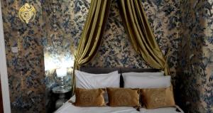 a bed with a canopy in a room with wallpaper at The Celtic Pride Hotel in Blackpool