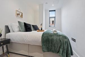 a bedroom with a bed with a green blanket on it at The Emerald Residence - Leicester - City Centre, Sofa Bed, Parking, Free WiFi, Netflix in Leicester
