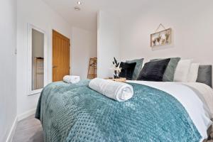 a bedroom with a large bed with towels on it at The Emerald Residence - Leicester - City Centre, Sofa Bed, Parking, Free WiFi, Netflix in Leicester