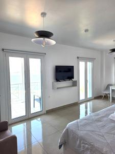 a bedroom with a bed and a tv on the wall at 12 Gods Resort in Pylos