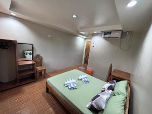 a room with a bed with two teddy bears on it at Eme's Apartelle in General Luna