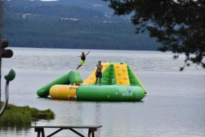 two people are riding on an inflatable raft in a lake at Sveastranda Camping in Gjøvik