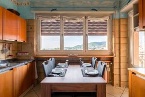a kitchen with a table and chairs and two windows at Viewpoint House in Alzano Lombardo