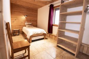 a bedroom with a bed in a wooden cabin at Gite du Brin d'Herbe in Pontarlier