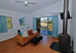 a living room with a couch and a wood stove at Beltana Villas in Pokolbin
