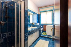 a blue bathroom with a sink and a mirror at Viewpoint House in Alzano Lombardo +12 photos