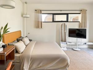 a bedroom with a large bed and a tv at The Arch Casa - Design Hotel Pai ,Free Fast WiFi in Pai
