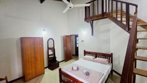 a bedroom with a bed and a wooden staircase at The Kandy City Townhouse in Kandy
