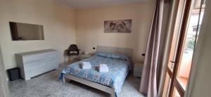 a bedroom with a bed and a tv and a window at Mara casa vacanza in Maracalagonis