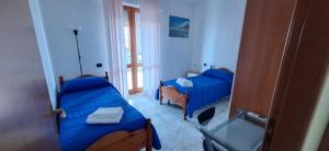 a bedroom with two beds and a window at Mara casa vacanza in Maracalagonis +18 photos