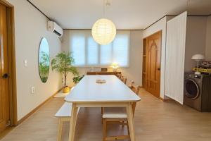 a dining room with a white table and a washer at Sai-gil stay in Busan +55 photos