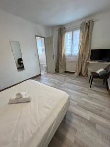a bedroom with a bed and a desk and a chair at Hôtel Le Square in Capvern