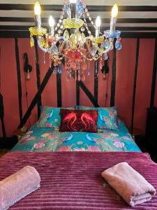 a bedroom with a bed with a chandelier at Romantic Boutique Cottage with pink roll-top bath-Hastings Old Town in Hastings
