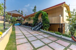 a garden with a walkway next to a building at River and Roots Resort, Riverside Boutique Stay , Bonfire, Scenic Views in Dehradun