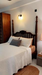 a bedroom with a large bed with a wooden headboard at Villa Vikasa Colombo in Colombo