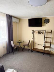 a hotel room with a table and chairs and a clock at SergJuli Villa in Plavecký Štvrtok