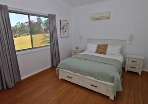 a bedroom with a bed and a large window at Beltana Villas in Pokolbin +23 photos