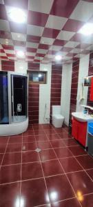 a bathroom with a red tiled floor with a toilet and sink at Villa Nabran in Nabran +19 photos