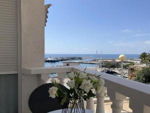a vase of flowers on a balcony with a view of the ocean at Mirador mar in L'Ametlla de Mar
