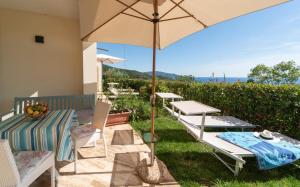 a patio with a table and chairs and an umbrella at Villa di Sogno in Palazzo