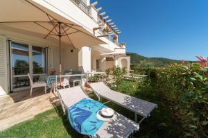 a patio with two chairs and an umbrella at Villa di Sogno in Palazzo +69 photos