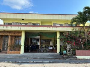 a yellow building with bikes parked in front of it at Adventure Hostel う島や in Iriomote