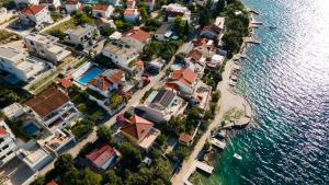 an aerial view of a group of houses next to the water at Villa A'Mare in Seget Vranjica +21 photos
