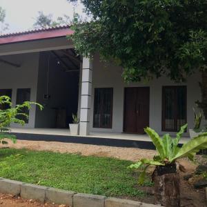 a house with a tree in front of it at Amelia Villa in Gandara West