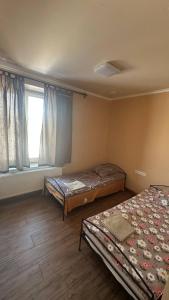 two beds in a room with a window at Motel Ararat in Rava-Rusʼka