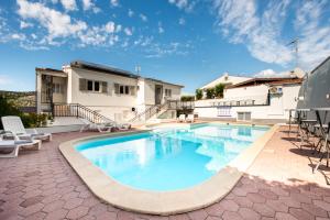 a swimming pool on a patio with a house at Villa A'Mare in Seget Vranjica