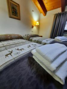 three beds are lined up in a room at Casa Vacanza Dal Contadino in Corteno Golgi