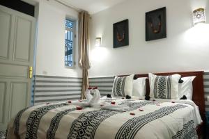 a bedroom with a bed with two birds on it at Riad Allal in Marrakesh