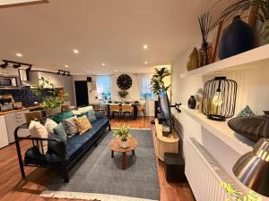 a living room with a blue couch and a table at Cozy Cottage Coventry self check-in after 3pm, Pets Friendly in Longford