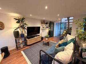 a living room with a couch and a flat screen tv at Cozy Cottage Coventry self check-in after 3pm, Pets Friendly in Longford +23 photos