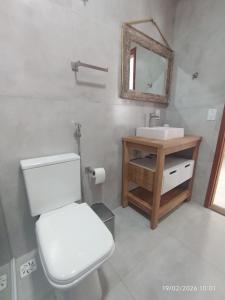 a bathroom with a toilet and a sink and a mirror at Casa Lego Paraty in Paraty +53 photos