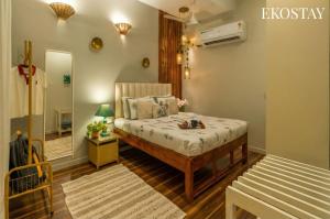 a small bedroom with a bed and a mirror at EKOSTAY - Copacabana Villa in North goa