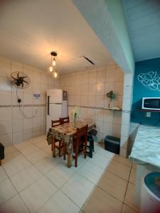 a kitchen with a table and a refrigerator at Aconchego famíliar in Mongaguá +11 photos