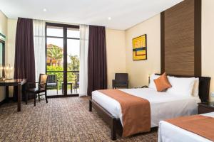 a hotel room with a bed and a desk at Hotel 33 Kampala in Kampala