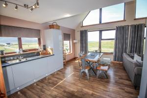 a kitchen and living room with a table and a couch at Otter Cottage in Leverburgh