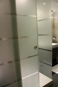 a glass shower door in a bathroom at Hotel Freimühle in Girod +10 photos