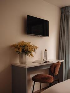 a room with a desk with a television and two chairs at Adam's Museum House in Amsterdam